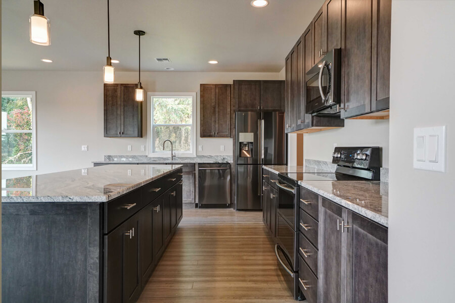 Photo of custome kitchen with dark grey cabinetry and and large rectangular island.