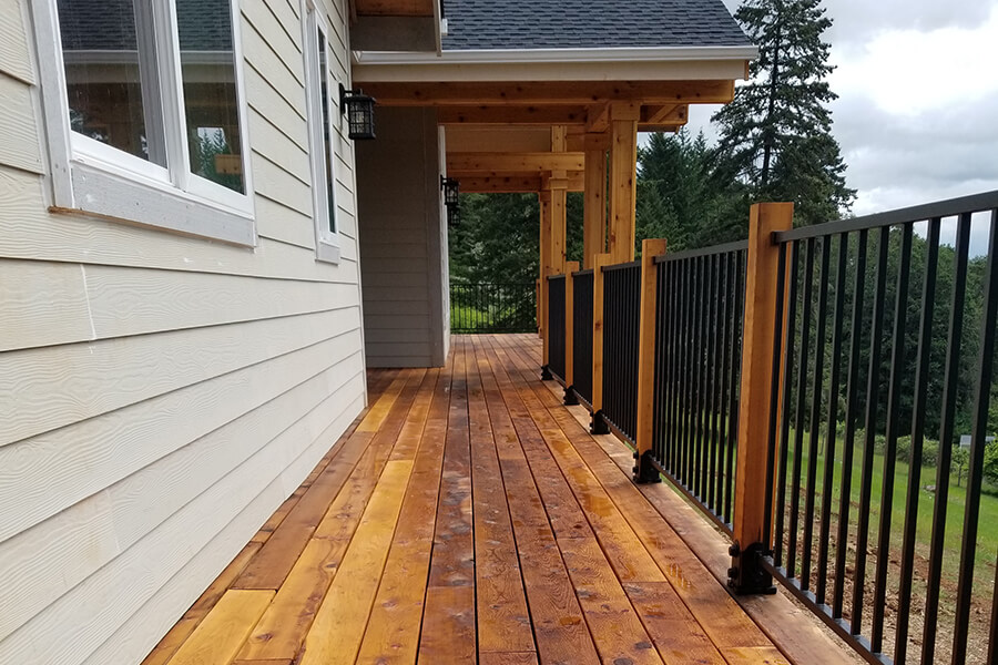Photo of wood deck and balcony with black iron railing.