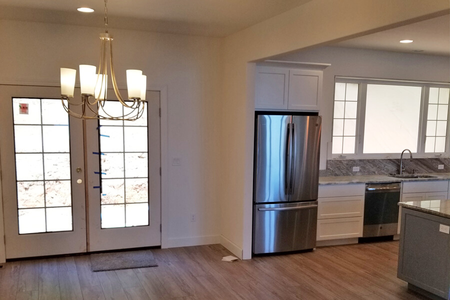 Photo of a custom dining area and French doors next to the kitchen.