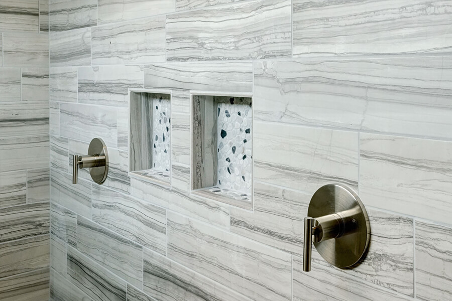Photo of a custom dual shower with light hardware and two built-in shelves.