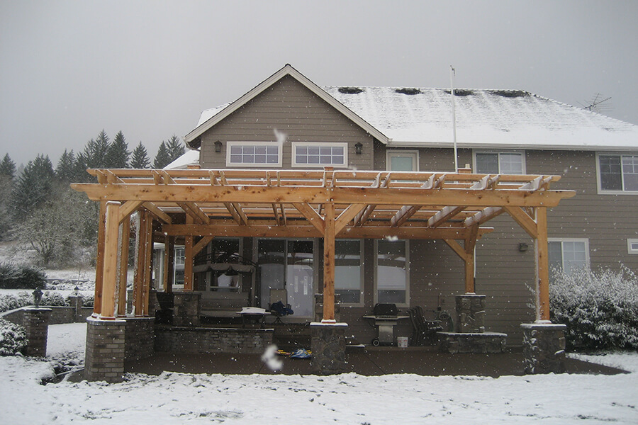 Photo of a light wood backyard pergola addition in snow.