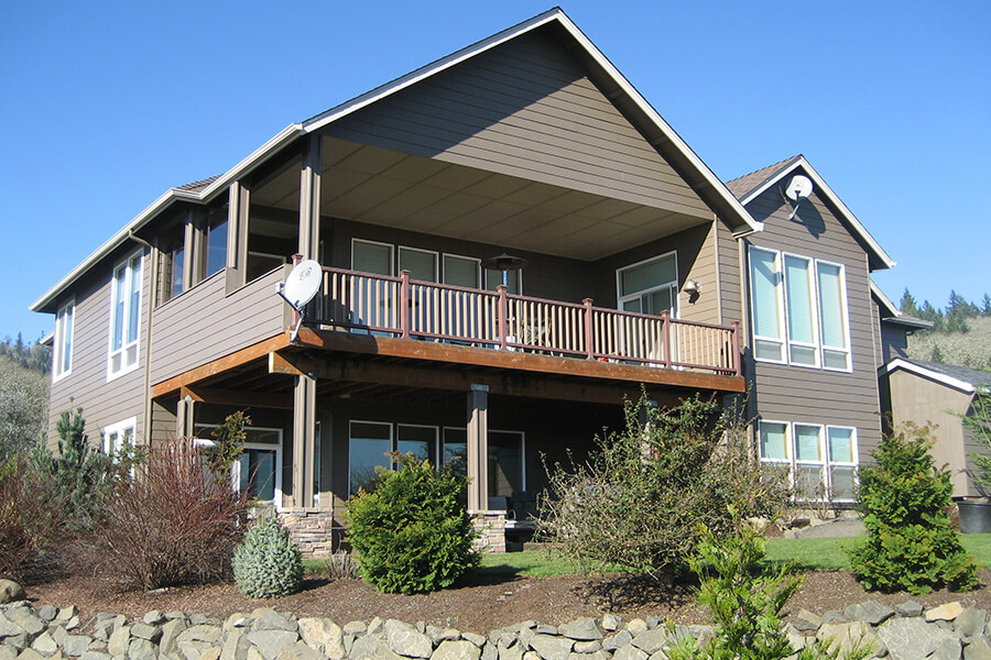 Photo of the outside of a Contemporary Craftsman home with front proch and second story balcony.