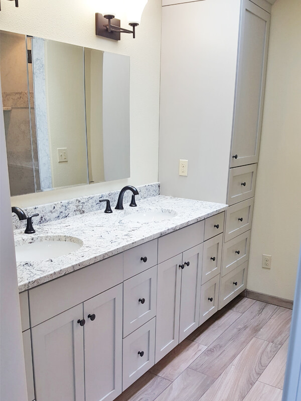 Photo of two sink vanity with lots of storage with grey drawers and cabinets.