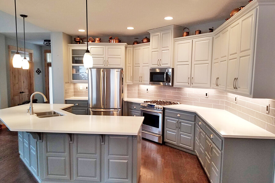 Photo of Contemporary Craftsman outside kitchen with white counters and grey cabinets.