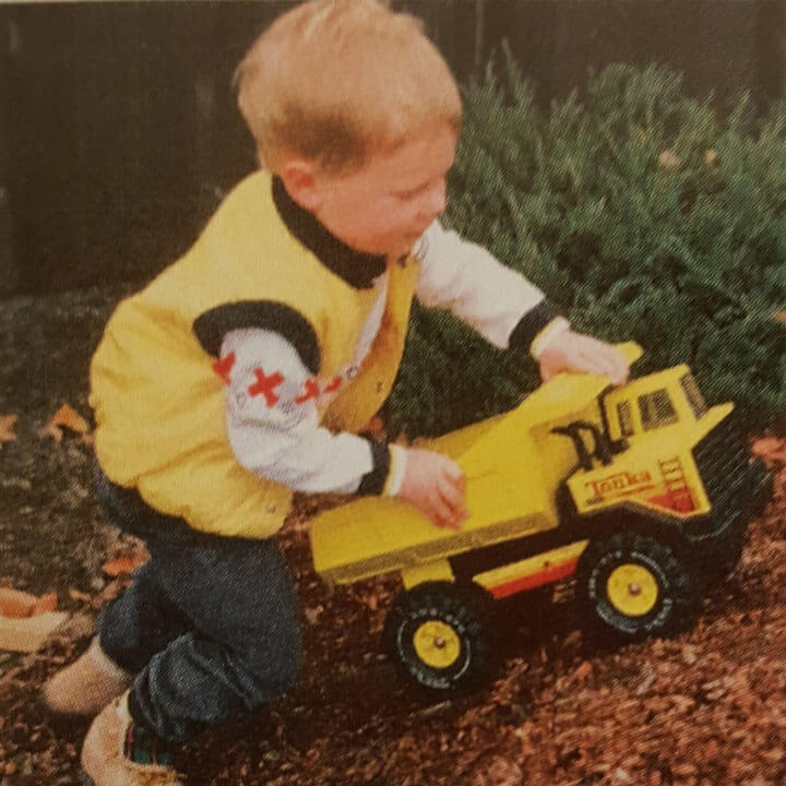 Photo of Ben Stiehl as a child playing with a Tonka truck.