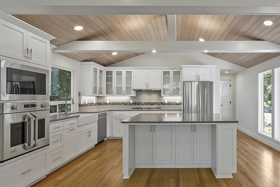 Photo of beautiful kitchen with wood floors and white beams.
