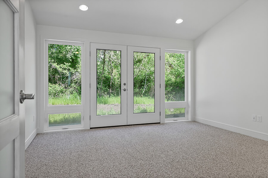 Photo of Contemporary Craftsman double French doors and large side windows with white molding.