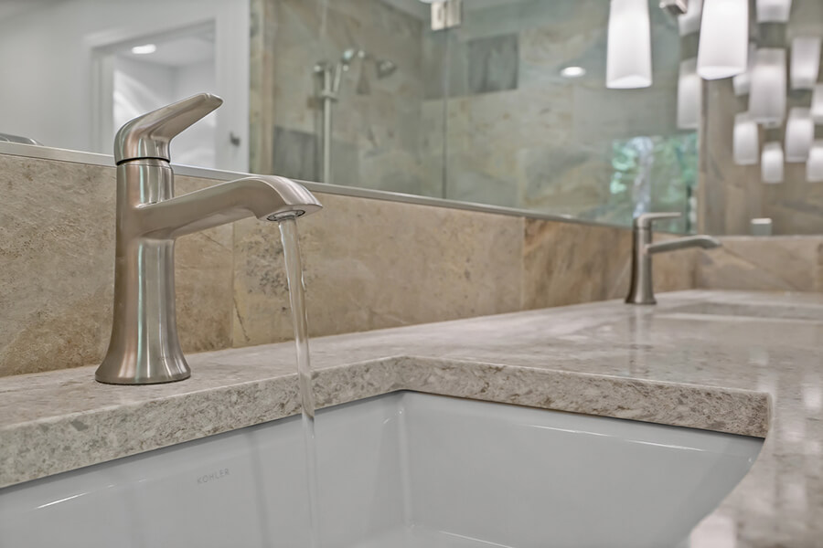 Photo of brushed nickel faucet with water running.