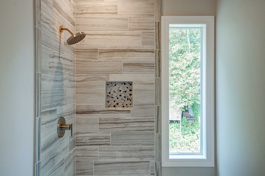 Photo of Contemporary Craftsman bathroom shower with grey tile and long window next to the shower