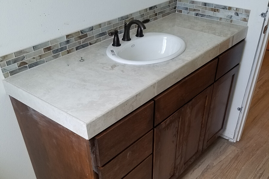 Photo of bathroom sink and cabinets with tile backsplash